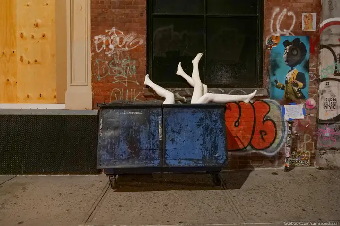 A photo of mannequins sticking out of a garbage